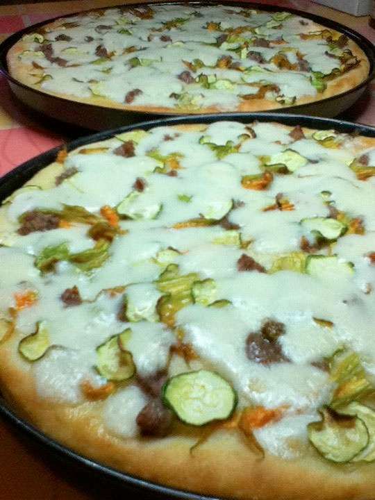 Pizza con fiori di zucca, salsiccia e zucchina